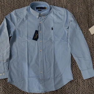 Ralph Lauren Shirt - Brand new blue Ralph Lauren shirt. Size is S. Unisex. Fast shipping.