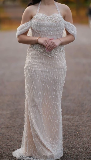 Champagnefärgad pärlklänning med axelband - Säljer en elegant långklänning i champagnefärg med pärlbroderier över hela klänningen. Klänningen är  använd endast några timmar. Passar storlek 36–42. ( Ny pris 5000kr) säljer den för 2000kr, priset kan diskuteras vid snabb affär. Fler bilder kan skickas 