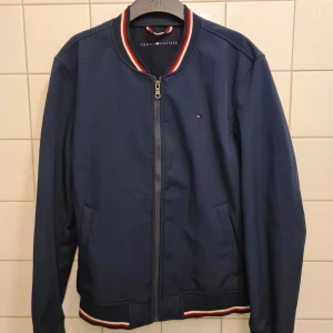 Tommy Hilfiger Bomberjacka - Nypris - 1200 SEK Stilig marinblå bomberjacka från Tommy Hilfiger med dragkedja fram.   Mycket bra skick! Använd någon enstaka gång.