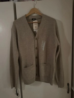 Uniqlo Cardigan/Kofta - Uniqlo cardigan – helt oanvänd med tags  kvar. Säljer en helt ny cardigan från Uniqlo, aldrig använd och prislappen sitter kvar. Har bara hängt i garderoben. Passar till det mesta, mjuk och skön kvalitet. Storlek M