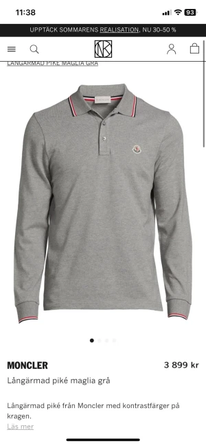 Grå långärmad pikétröja Moncler - Snygg grå långärmad pikétröja från Moncler med klassisk krage och knappar. Tröjan har diskret Moncler-logga på bröstet och coola kontrastdetaljer i rött och vitt på krage och ärmslut. Tillverkad i mjuk bomull som är skön mot huden.