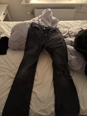 Mid waist jeans från Gina - Säljer dessa bootcut mid waist jeansen från Gina med ett hål på ena knäet. Inte använda så mycket, säljs då dom inte används längre. Dom är mörkgråa. Storlek 36 🥰