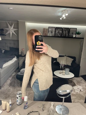 Beige ribbad stickad tröja Pieces - Säljer en beige stickad tröja från Pieces i storlek S. Tröjan har ribbad struktur, lång ärm och slits på sidorna vilket ger en chill och avslappnad vibe. Perfekt att matcha med jeans för en enkel och snygg look.