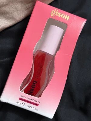 Gisou Honey Infused Lip Oil Cherry - Cherry on the Cake honey infused lip oil från Gisou, 8 ml. Ger intensivt återfuktade och glansiga läppar med en skimrande röd färg. Kommer i en snygg rosa förpackning med körsbärsmotiv och har en mjuk applikator. Innehåller naturliga oljor och honung.