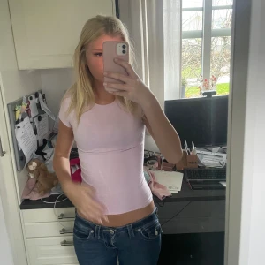 Ljusrosa t-shirt från Gina Tricot - Säljer en ljusrosa t-shirt från Gina Tricot i storlek XS. Modellen är klassisk med rund hals och korta ärmar, och sitter tight mot kroppen. Materialet är mjuk bomull som känns skönt mot huden. Perfekt att matcha med jeans eller kjol för en enkel och fräsch look.