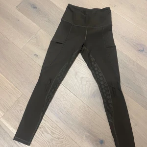 Maya delorez ridbyxor - Maya delorez ridbyxor i gråbrun färg super sköna. Har dock en skada på knät som vi försökt sytt storlek XS 🥰