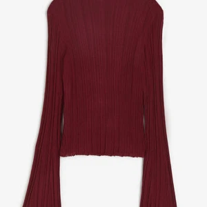 Vinröd ribbad långärmad topp - Säljer en vinröd ribbad långärmad topp med vida ärmar. Tröjan har en snygg figurnära passform och är tillverkad i ett stretchigt material som sitter skönt på kroppen. Perfekt för dig som vill ha en trendig och stilren look.