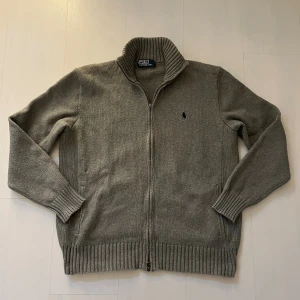 Grå stickad kofta från Polo Ralph Lauren - Grå Stickad kofta från Ralph Lauren Riktigt varm och skön  Mycket fint skick bara att lite av dragkedjan har lossnat (se bilden)  Storlek M