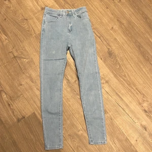 Ljusblå skinny jeans med hög midja - Snygga ljusblå skinny jeans med hög midja och klassisk femficksdesign. Jeansen har smal passform och är tillverkade i mjukt denimtyg som ger en bekväm känsla. Perfekta för dig som gillar en stilren och enkel look.