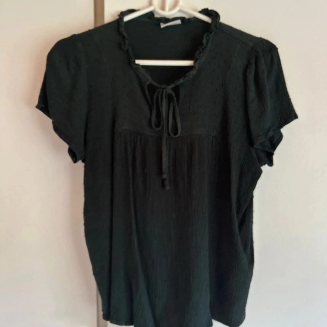 Svart blus med knyt och volang