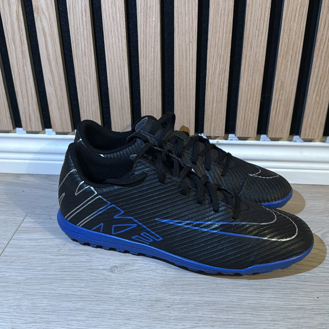 Svarta Nike fotbollsskor med blå sula