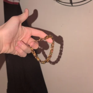 Guldigt kedjearmband - Snyggt armband med chunky kedjelänkar i guldig färg. Armbandet har en cool och modern design som sticker ut på handleden. Perfekt för dig som gillar statement-smycken och vill addera lite extra bling till din stil. Har ej koll på mm osv 