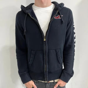 Hollister Zip-up Hoodie - Hej! Säljer nu denna super populära Hollister hoodie för 679kr!!! Skick 8,5/10✅. Priset ej hugget i sten🪨⛏️. Hör av dig vid minsta fundering!