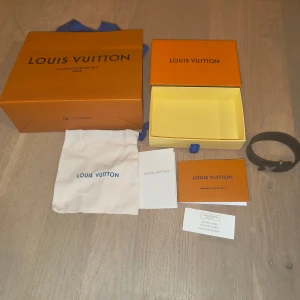 Svart Louis Vuitton armband i skinn - Säljer ett svart Louis Vuitton armband tillverkat i kalvskinn med klassiskt monogrammönster och stilren LV-spänne i metal . Armbandet  har textilfoder och vachette-detaljer. Kommer med originalförpackning, dustbag och äkthetskort. Perfekt för dig som vill ha en lyxig stilren look