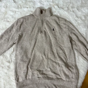 Beige stickad half zip från Polo Ralph Lauren - Säljer en beige stickad tröja från Polo Ralph Lauren med half zip och hög krage. 