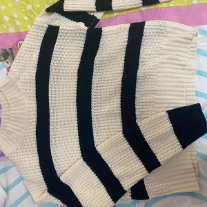 Randig stickad tröja i svart och vit - Snygg stickad tröja med breda svarta och vita ränder. Modellen har långa ärmar med. Tröjan är loose fit som passar till jeans eller kjol. 