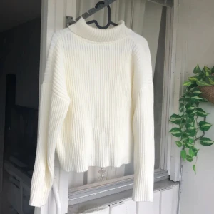 Vit ribbad polotröja i stickat material - Supermysig vit polotröja med ribbad struktur och lång ärm. Tröjan är stickad och har en hög krage som ger en chill och stilren vibe. Mycket stretch i, så den är S men är mer som M tycker jag. Men den passar S-L