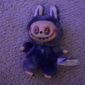Pop Mart The Monsters Bunny Plush - Secret!!!! Unik Pop Mart The Monsters Bunny plush med färgglada ögon och mjuk pälsdräkt. Samlarobjekt i mycket fint skick, inga synliga defekter eller slitage. Perfekt för Pop Mart-fans eller som present. Originaletiketter kvar. 