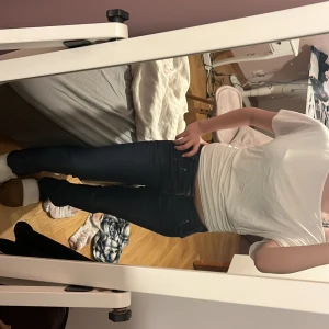 Mörkblå  jeans från Lee - Säljer ett par mörkblå jeans från Lee med klassiska femficksdetaljer och snygga kontrastsömmar. Jeansen har låg midja. Materialet är stretchigt denim som sitter tajt men bekvämt.