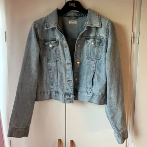 Ljusblå jeansjacka från Lindex - En super söt jeans jacka från Lindex i storlek 170/M men den sitter bra för folk med storlek s/xs, säljer för den inte används. I fint skick! Har typ bara använt den 1 gång på skolavslutning.