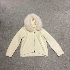 Vit stickad jacka med päls - Vit jacka med päls alldrig använd köpt för 1200 inte den från alessa för de va ngn annan sida så pälsen är ej äkta därav säljer jag den och för hälften av priset jag köpte den för, men dem ser därimot exakt lika dana ut skulle jag säga då jag köpt från alessa nu,  står ej storlek i men är som en xs skulle jag säga då den passar mig  
