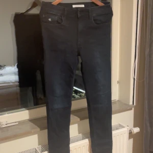  jeans från Calvin Klein - Mörkblåa skinny jeans från Calvin Klein Jeans med klassisk femficksdesign och diskret CK-logga på fickan. Jeansen har smal passform och är tillverkade i stretchigt bomullsmaterial för en bekväm känsla. Perfekta för dig som gillar stilrena och tidlösa jeans.