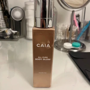 CAIA All Over Body Glow Golden Tan - Glowig body highlighter från CAIA i nyansen Golden Tan. Kommer i en fyrkantig flaska med silvrig pump och ger huden en skimrande, solkysst look. Perfekt för att framhäva brännan och ge extra lyster till kroppen, den är andvänd en gång så burken är helt fylld. Säljer pågrund av hudproblem så kan inte använda produkten! Men jätte fin på, kan andvändas som highlighter för sminket också ❣️i färgen golfen tan 