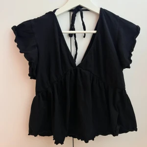 Svart topp / blus  - Säljer denna svarta toppen / blusen från lager 157 då den ej används ❣️ använd några gånger! Har knyte i ryggen 