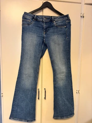 Low waist jeans - Snygga blå utsvägda jeans med  låg midja. Dem har använts några gånger men är i gott sick och har inga tecken på skada. De är i storlek 44 och ser lite mörkare ut på de bilderna jag tod, men i verkligheten är de ljusare som på bilderna tagna direkt från hemsidan jag köpte de ifrån😊