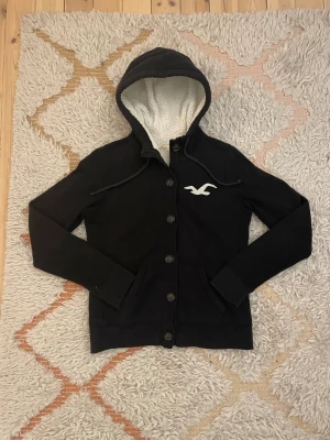 Svart cardigan från Hollister - Snygg Hollister cardigan i storlek M men sitter som XS efter som det är barnstorlek. Hör av dig vid minsta fundering