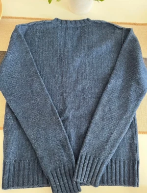 Blå vintage stickad v-ringad tröja Jack & Jones - Snygg blå stickad tröja från Jack & Jones i storlek M. Tröjan har v-ringad hals och långa ärmar med breda ribbade muddar vid ärmslut och nederkant. Perfekt för dig som gillar enkel och stilren design med en chill vibe. Använd bara 1 gång.