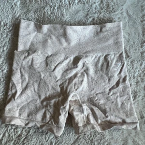 Shorts från Gymshark - Säljer ett par beige(lite toner av rosa) shorts från Gymshark! Sitter snyggg och är sköna att ha på sig! Säljs då de har blivit försmå för mig.. I fint skick, inte använda så mycket🌼Storlek S, 200kr