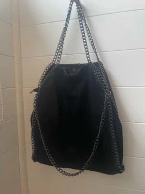 Svart kedjeväska - Säljer den här svarta kedjeväskan från design by amor! Den är aldrig använd💓original pris 400kr