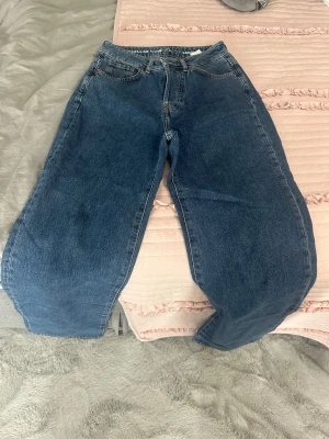 Blå wide jeans med hög midja - Säljer ett par blå jeans med breda ben och hög midja. Klassisk femficksmodell i denim med regular wide fit. Perfekta för dig som gillar en avslappnad och trendig look.