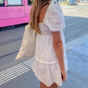 Vit klänning/ studentklänning - Superfin vit kort klänning med broderade blommor och puffiga korta ärmar. Klänningen har fyrkantig urringning och volangkant nertill, perfekt för varma dagar. Tillverkad i luftig bomull som känns skön mot huden. Kan användas vid studenten också! Jag har vanligtvis S.