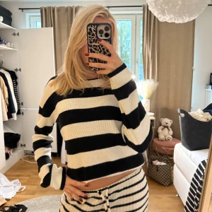 Randig stickad tröja - Säljer en croppad stickad tröja med breda svarta och vita ränder. Tröjan har lång ärm och en loose passform, perfekt för en chill och trendig look. Supermjuk och skön att ha på sig, passar till både jeans och mjukisbyxor. Barnstorlek men skulle säga att det passar en Xs🥰