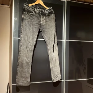 Svarta jeans från Neuw - Snygga svarta jeans från Neuw med klassisk femficksdesign och diskret logga på bakfickan. Jeansen har en rak passform och är tillverkade i slitstarkt denimtyg. Perfekta för dig som gillar en stilren och tidlös look.