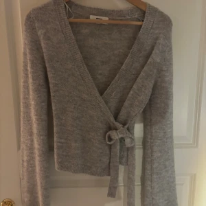 Grå omlottkofta från Gina Tricot - Superfin knyt kofta från Gina Tricot. Som ny! Aldrig använd, inte kommit till användning då den vart lite liten. Hör av dig vid intresse,🩷 