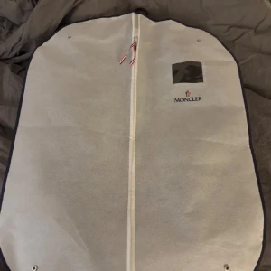 Moncler cardigan  - Svart pufferjacka från Moncler med glansig, quiltad front och stickade ärmar. Jackan har dragkedja framtill och Moncler-logga på ärmen. Perfekt för dig som vill ha en snygg och modern look med exklusiv känsla. Kommer med original klädpåse. Nfc fungerar byten funkar också, S men passar som M