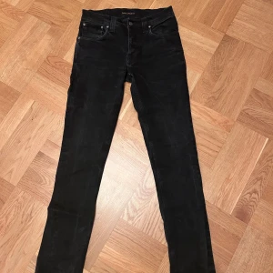 Nudie Jeans Grim Tim 32/34 - Svarta jeans från Nudie Jeans, modell Grim Tim, i storlek 32/34. Skönt matrial med lite stretch. Obs är Jeansen lite fläckiga baktill, inget som syns när man bär dom, med det är priset lite reducerat. Hör av dig vid minsta fundering
