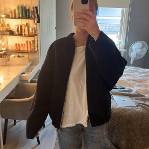 Svart teddyjacka från Zara - Mysig svart slutsåld populär jacka från Zara med oversized passform och lång ärm. Jackan har en grov dragkedja framtill och är tillverkad i ett fluffigt teddy-material som ger en cool och avslappnad vibe. Perfekt för kyligare dagar när du vill vara både varm och snygg.