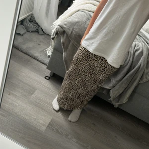 Leopardmönstrad långkjol  - Snygg långkjol från Karo Kauer med leopardmönster i beige och svart. Kjolen har en rak och flowy passform med dragkedja i sidan 💗