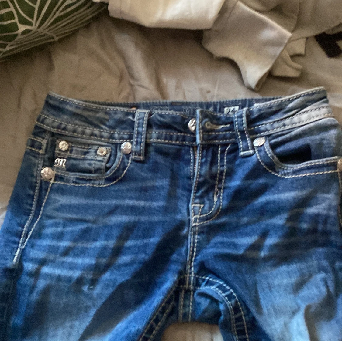 Blå jeans med broderade bakfickor