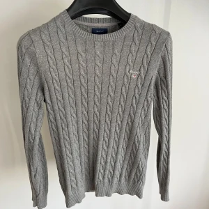 Grå kabelstickad tröja från GANT - Snygg grå kabelstickad tröja från GANT i storlek S. 