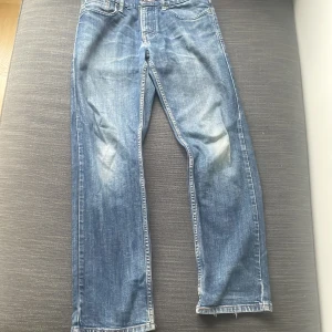 Levi's 514 blå jeans straight fit - Klassiska blå Levi's 514 jeans med straight fit och snyggt slitna detaljer. Jeansen har fem fickor, normal midja och är i storlek 32/32. Tveka inte på att göra av dig om du undrar över något😁