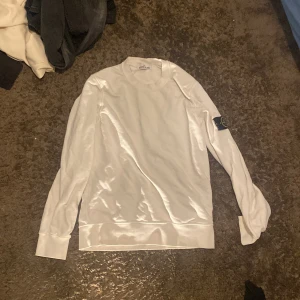 Vit Stone Island sweatshirt S - Vit långärmad sweatshirt från Stone Island i bomull. Klassisk rund halsringning och ikonisk logotyp-patch på vänster ärm. Enkel och clean design som passar perfekt till jeans eller trackpants.