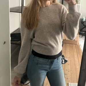 Beige stickad tröja från & Other Stories - Säljer en mysig beige stickad tröja från & Other Stories. Tröjan har långa ärmar och ribbade muddar vid ärmslut och nederkant. 