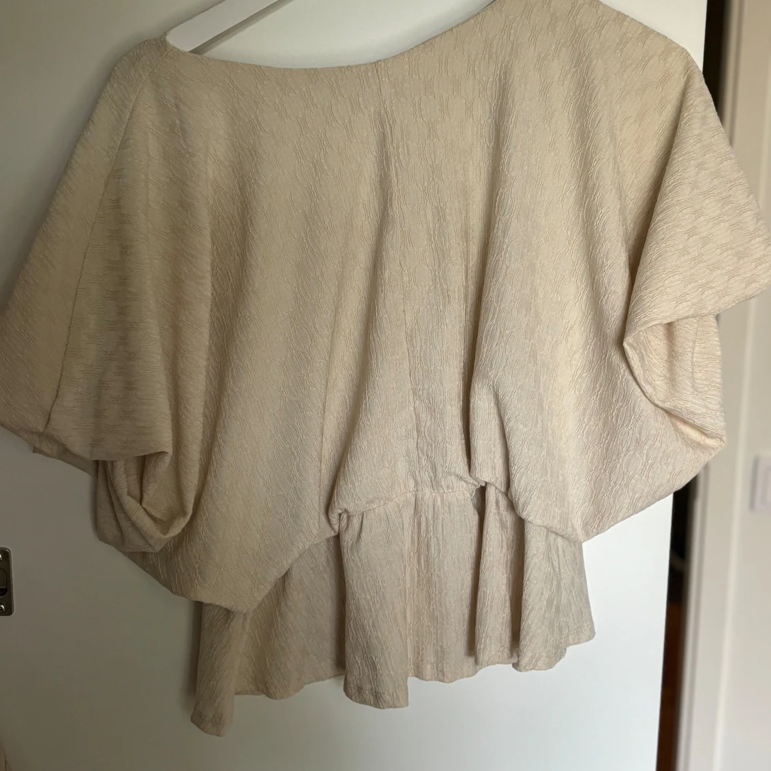 Beige blus med volang och v-ringning