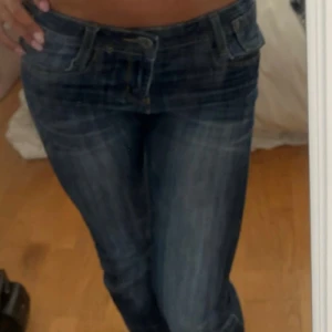 Blå low waist jeans från Monday Denim - Snygga blå jeans från Monday Denim med låg midja och klassisk femficksdesign. Jeansen har en tvättad look med ljusare partier framtill och smal passform. Märkesdetaljer i metall och leopardmönstrad patch bak. Perfekta för dig som gillar en trendig och avslappnad stil.