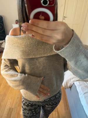 Beige offshoulder stickad tröja H&M - Supermysig beige stickad tröja från H&M med bred offshoulder-krage. Tröjan har långärmade ärmar och en passform som ger en chill vibe. Perfekt att styla med jeans eller leggings för en snygg look.